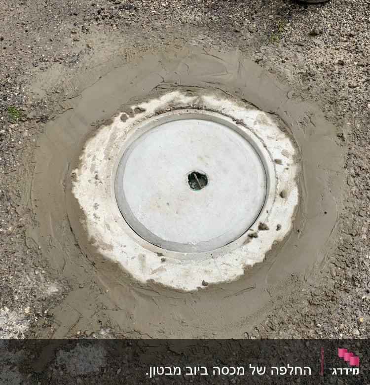 מכסה ביוב עגול מוקף בטון רטוב